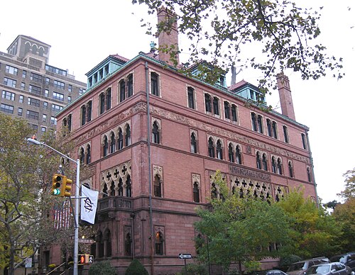The Montauk Club at Eighth Avenue and Lincoln Place, a red brick clubhouse with terracotta friezes and pointed arches, seen from the corner on a cloudy afternoon.