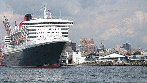 The Queen Mary 2 at the Brooklyn Cruise Terminal, seen from the water on a cloudy afternoon.