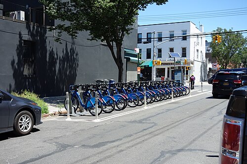 Van Brunt Street at Pioneer Street on a July afternoon, a bike rack in the roadway and low storefronts along the block.