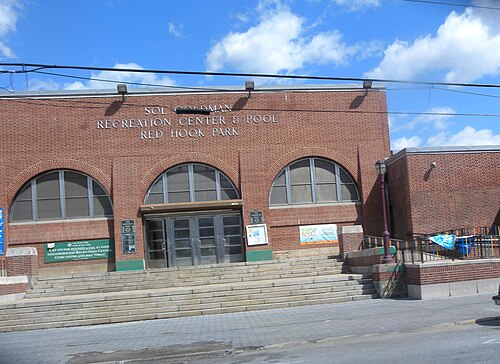 The Sol Goldman Recreation Center and Pool in Red Hook Park, a brick front with three arched windows and the name cut into the wall above them.