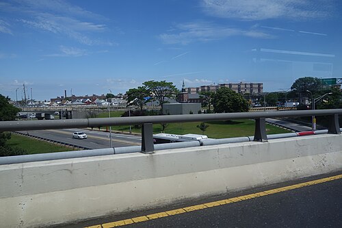 Coming off the south end of the Cross Bay Veterans Memorial Bridge, with the steeple of the First Congregational Church and flat roofed apartment slabs on the skyline.