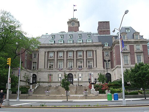 Staten Island Borough Hall seen from Richmond Terrace, a French Renaissance building in brick and limestone with a mansard roof and a clock tower over the entrance.