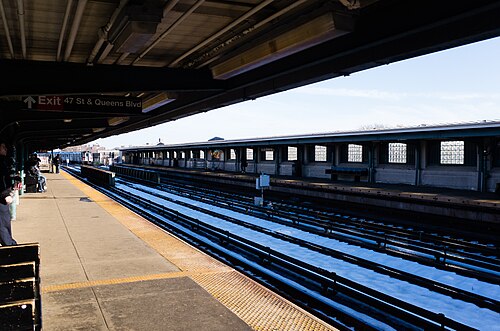 The elevated platform at the 46th Street stop on the 7 after snow, glass block windbreaks along the far platform.