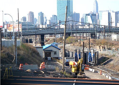 Sunnyside Yard seen west from the 39th Street bridge, tracks and catenary poles with the Long Island City towers behind.