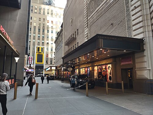 Shubert Alley looking south toward West 44th Street, bollards and a chain across the entrance and a theatre marquee with show posters along the right side.