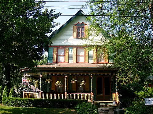 The Victorian house at 88 Bentley Street, painted green and orange with gingerbread trim and a wraparound porch.