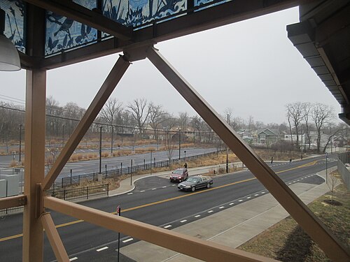 Arthur Kill Road seen from the Arthur Kill station overpass, the station parking lot and small houses along the road.