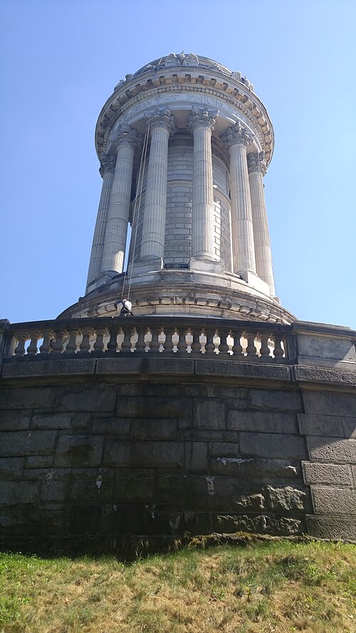The Soldiers' and Sailors' Monument in Riverside Park at 89th Street, a ring of columns on a granite base, seen from the grass below it.