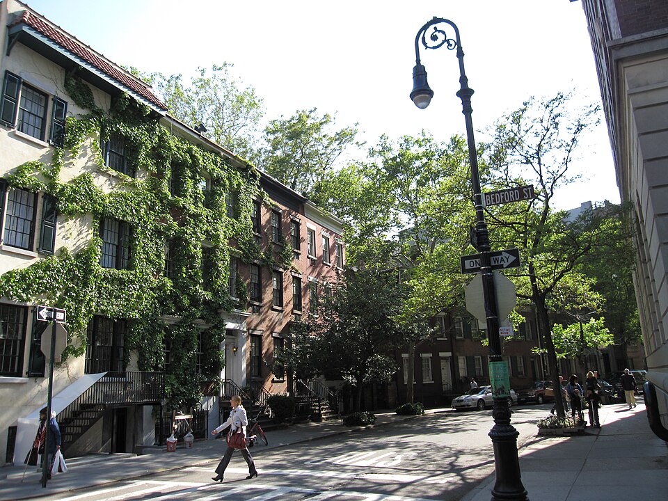 The corner of Grove Street and Bedford Street, an ivy covered house with a tiled roof on the near side and brick houses beyond it, with the Bedford Street sign on the lamppost.