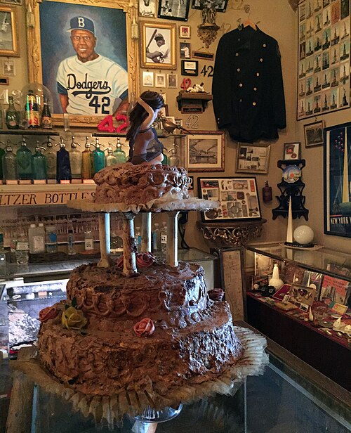 Inside the City Reliquary on Metropolitan Avenue, a painted portrait of Jackie Robinson over a shelf of coloured seltzer bottles, a police tunic on a hanger and cases of New York oddments.