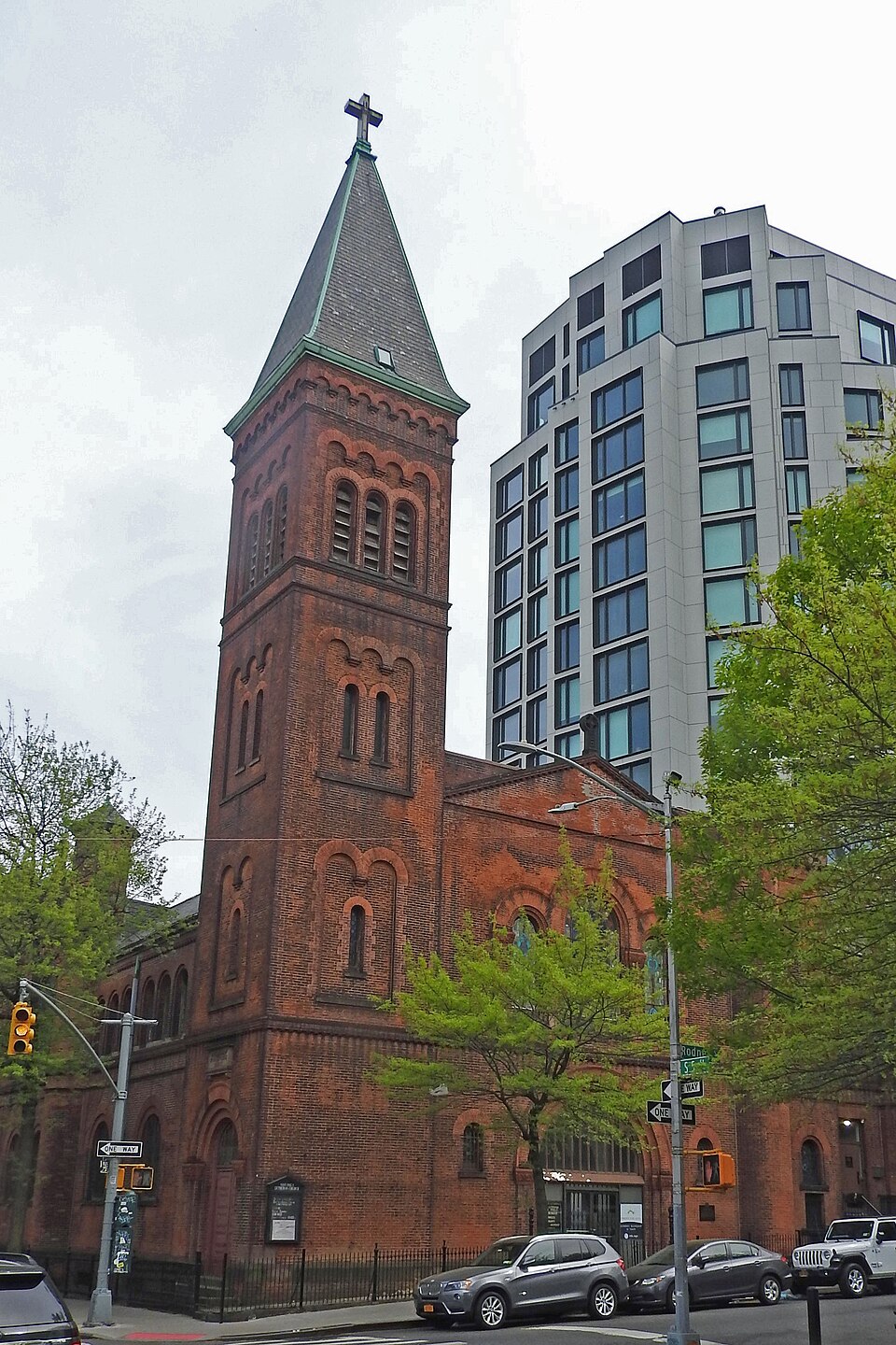 South 5th Street at Rodney Street, with the red brick tower of the former St Paul's Evangelical Lutheran Church on the corner and a glass apartment block standing directly behind it.