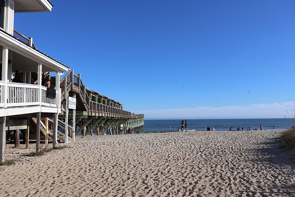The Oceanic restaurant built onto Crystal Pier, its upstairs deck and stairs down to the pier walkway, the wooden pier running out past the building toward the surf, THE OCEANIC sign visible on the railing.