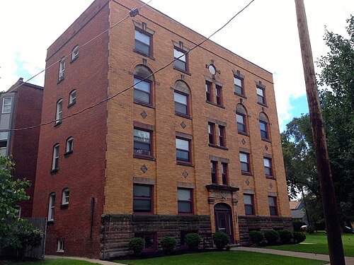 The Clinton Apartments, a four storey brick building with arched window heads, stone lintels and a carved nameplate over the entrance.