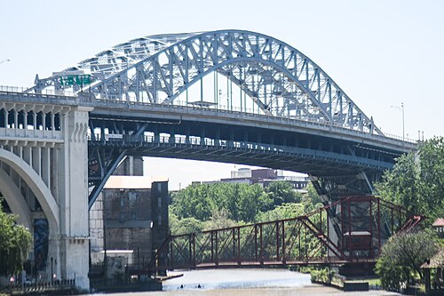 The Detroit-Superior Bridge's concrete and steel arch rising over the water, with the low red Center Street swing bridge visible beneath it.