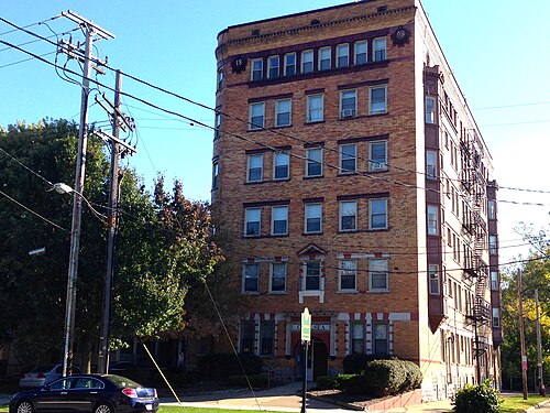 Chelsea Manor, a five storey brick apartment building with a rounded corner bay, iron fire escapes and a carved corner date stone.