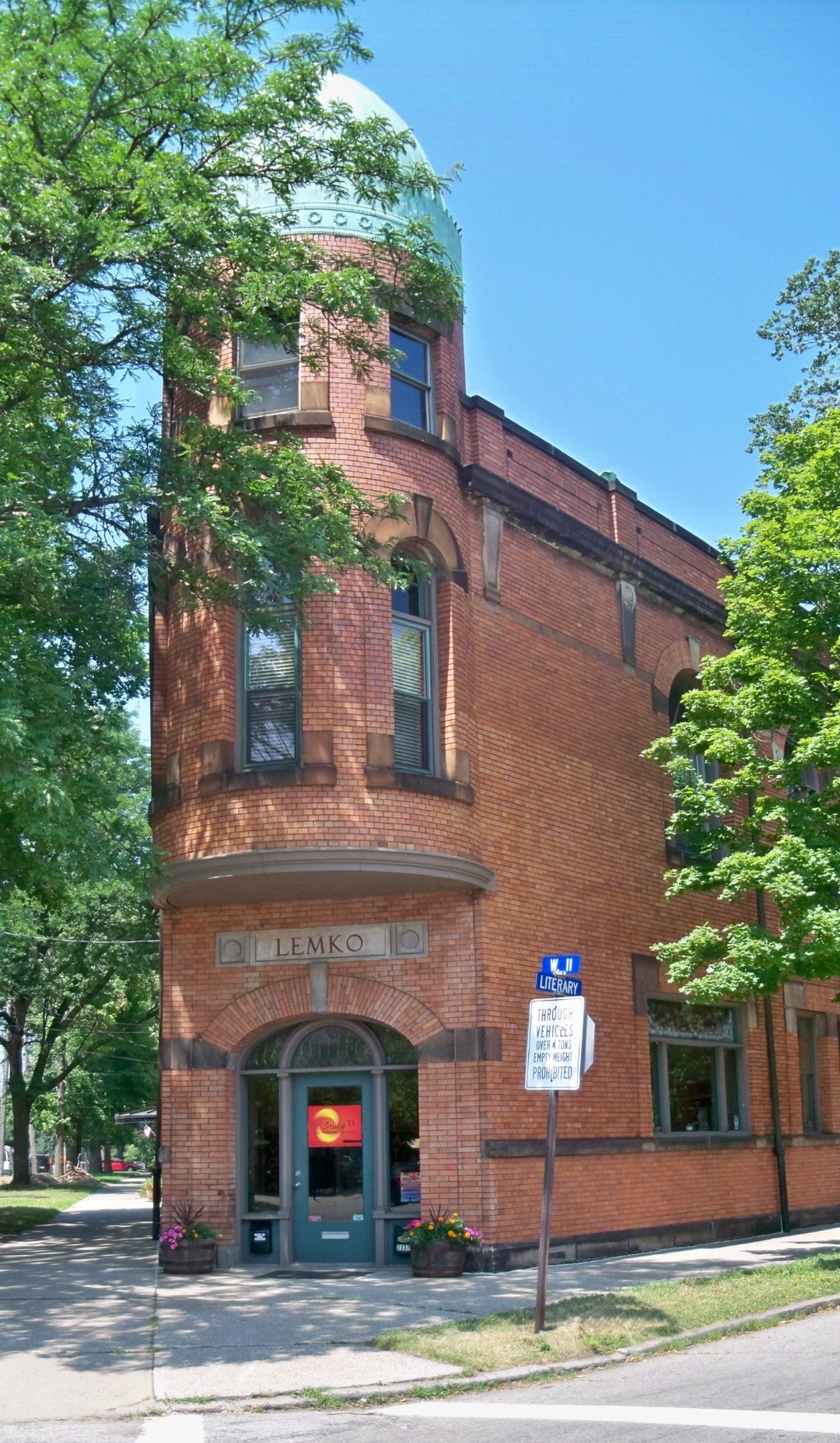 Lemko Hall's rounded red brick corner tower under a green dome, LEMKO carved over the arched entrance, at West 11th Street and Literary Avenue.
