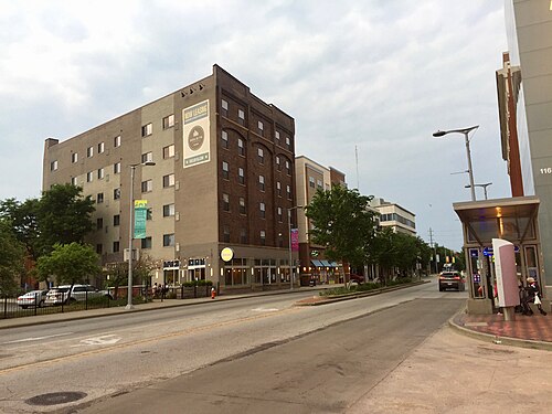 A multi storey brick apartment building beside Euclid Avenue, with a bus shelter in the foreground.
