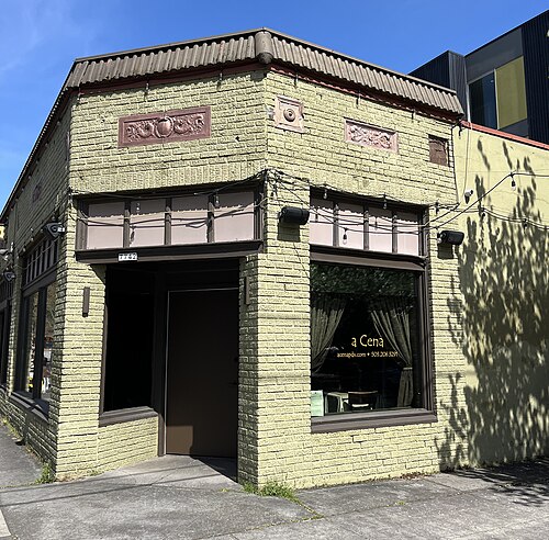 A Cena's storefront on SE 13th Avenue, a painted brick corner building with the restaurant's name lettered on the window.