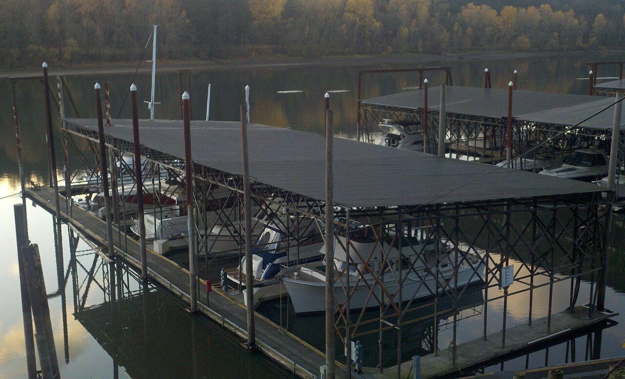 Covered boat slips on the Willamette River, boats tied up under the roofed docks.