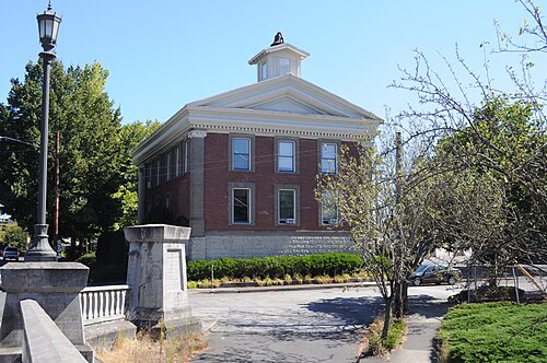 St. Johns City Hall, two storeys of red brick with a white pedimented cornice and a small bell cupola.