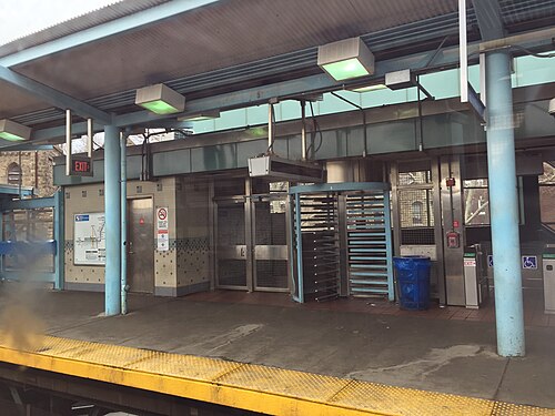 The York-Dauphin platform's turnstile exit and fare gates under the elevated line's steel canopy.