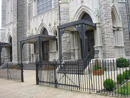 The Polish Cathedral style front of St. Adalbert Church at Allegheny and Thompson, stone steps behind a black iron fence.