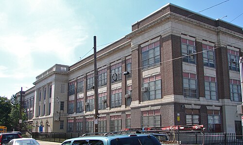 The brick front of the J.P. Jones School building on Memphis Street, stone trim over multi pane windows behind a black iron fence.