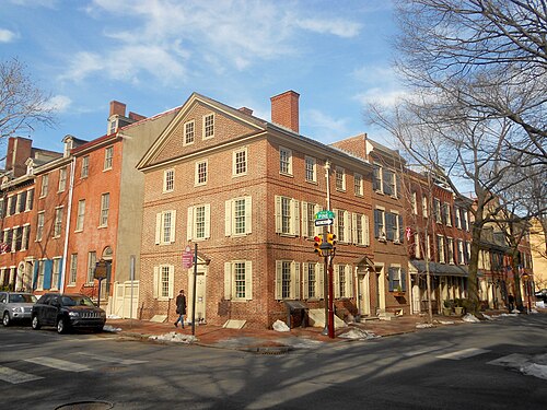 The Kosciuszko house at Third and Pine, a three storey Federal corner building in red and tan brick with a slate roof and dormer, a green street sign for Pine Street mounted on the corner post.