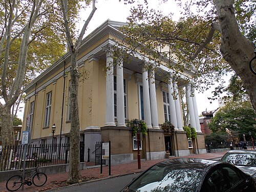 Old Pine Street Church's Greek Revival front on Pine Street, six fluted white columns under a triangular pediment, an iron fence and street trees along the sidewalk.