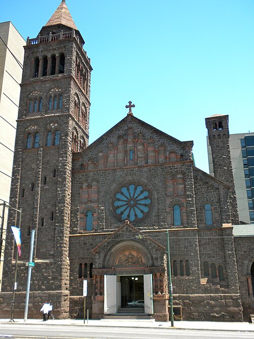 The Philadelphia Episcopal Cathedral's stone bell tower and blue rose window on Chestnut Street, a modern tower rising behind it.