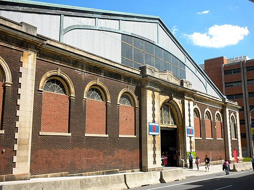 The old 32nd Street armory building, arched windows set into dark red brick under a curved barrel roof.