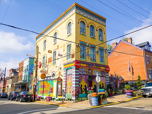 The Randyland corner building at Arch Street, painted yellow with found object folk art covering the facade and Randy Land signage over the entrance.
