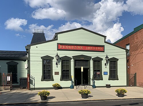 The Duquesne Incline's light green wooden station house, dark green trim, a red sign reading Duquesne Incline over the double doors.