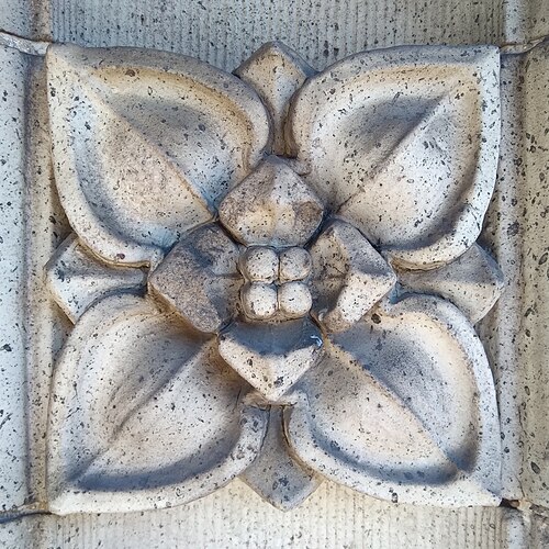A carved stone floral relief on the King Edward Apartments facade.