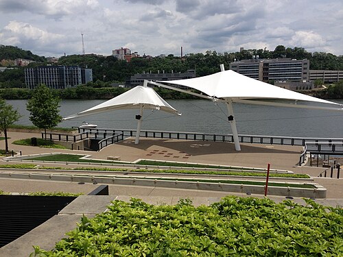 South Shore Riverfront Park, two white tensile canopies over a paved plaza facing the river.