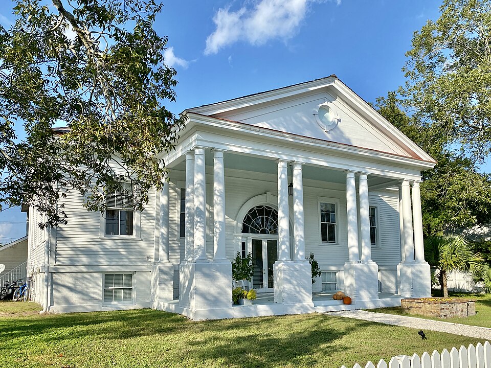 The Fort Moultrie Post Exchange, a white Neoclassical clapboard building with a pedimented portico and columns, on the fort's grounds.