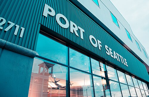 The Port of Seattle building at 2711 Alaskan Way, a teal metal clad facade with large white lettering and the street number, a glass storefront at ground level.