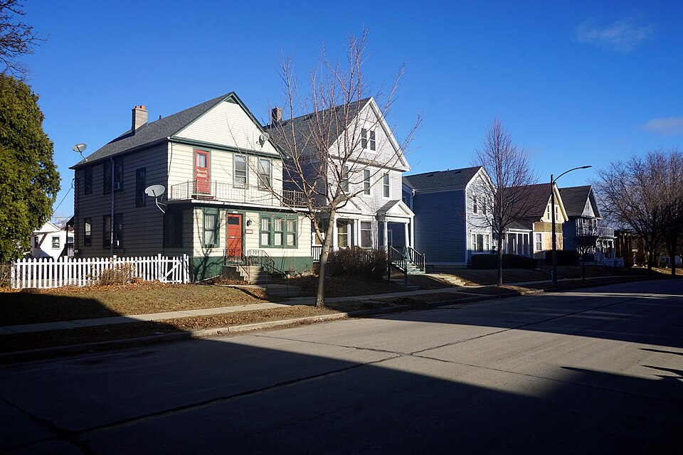 Two storey wood frame houses with a picket fence and a second floor porch on East Russell Avenue. The kind of frame apartment block the production used rather than the one, which is the Street View beside it.