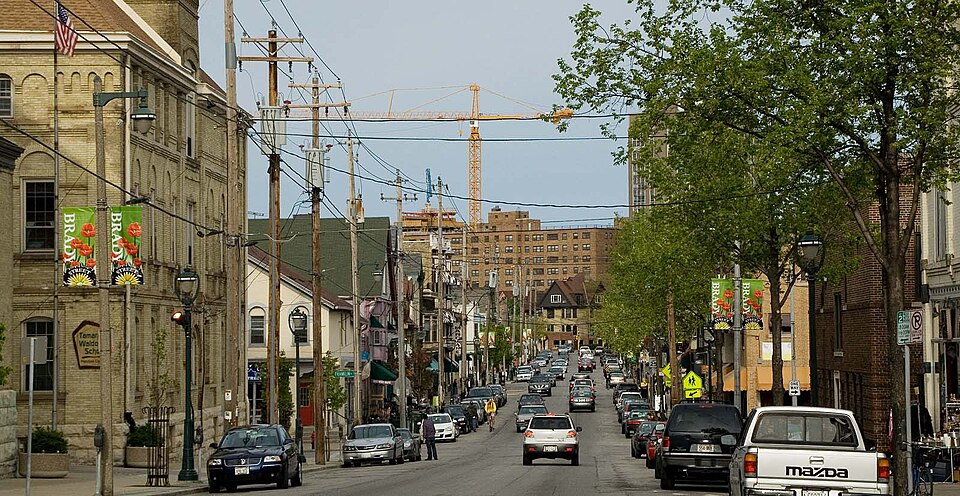 A block of Brady Street looking east, BRADY STREET banners on a lamppost, brick and frame storefronts receding down the block under overhead wires. A representative view of the corridor rather than the Cempazuchi storefront itself, for which no free photograph exists.